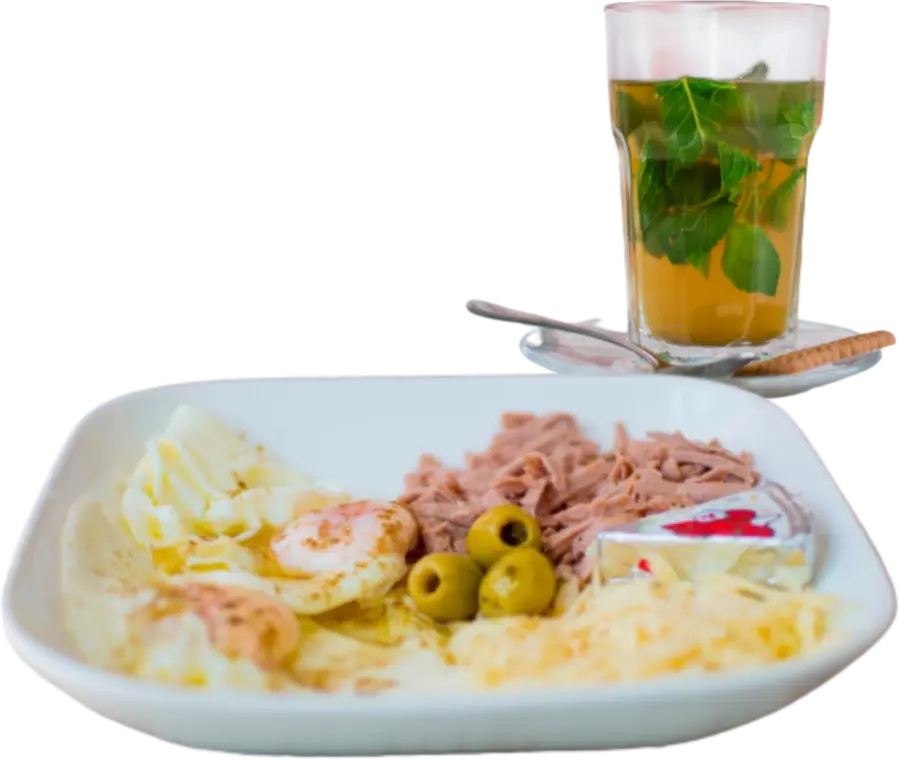 Marokkaans ontbijt met ei, kaas, olijven en een glas muntthee